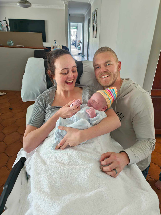 Ally and Simon holding newborn Bodan