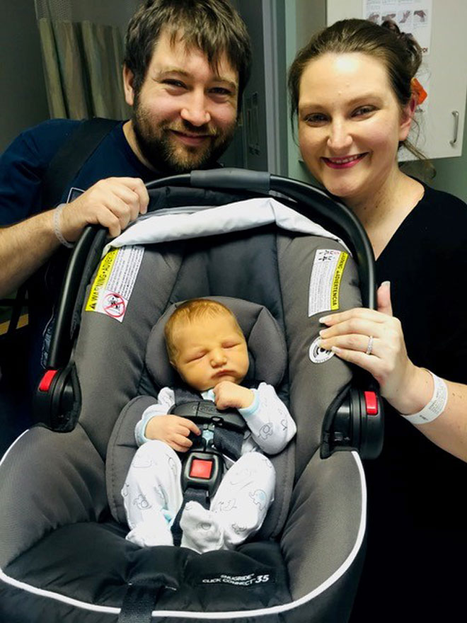 Abby with her husband and baby leaving hospital