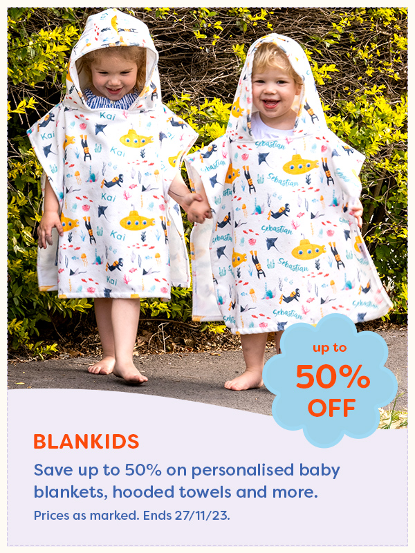 Two young girls holding hands wearing personalised hooded beach towels