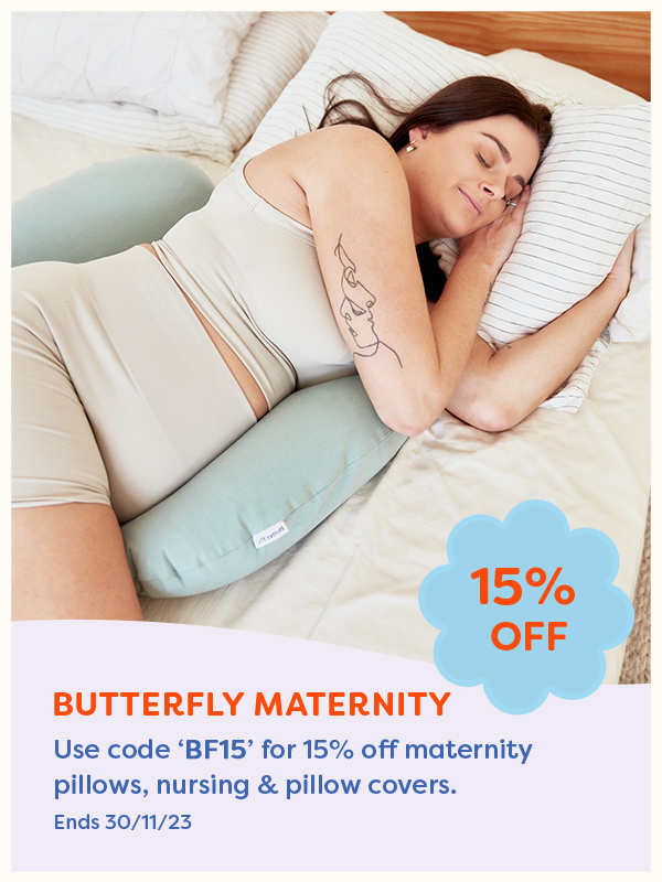 A pregnant woman laying with the Butterfly Maternity pregnancy pillow
