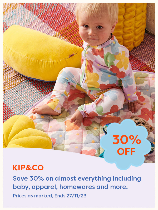 Young baby sitting on a colourful play mat in a matching romper from Kip&Co