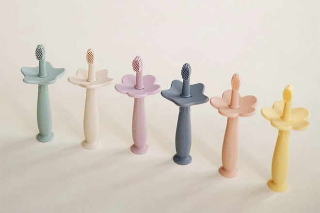 Mushie Baby toothbrushes showing a range of colours and guards in assorted shapes. 