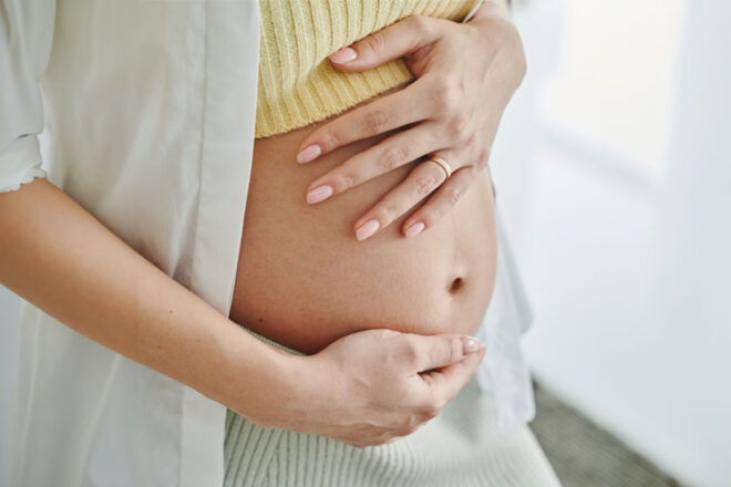 A pregnant woman cradling her bump