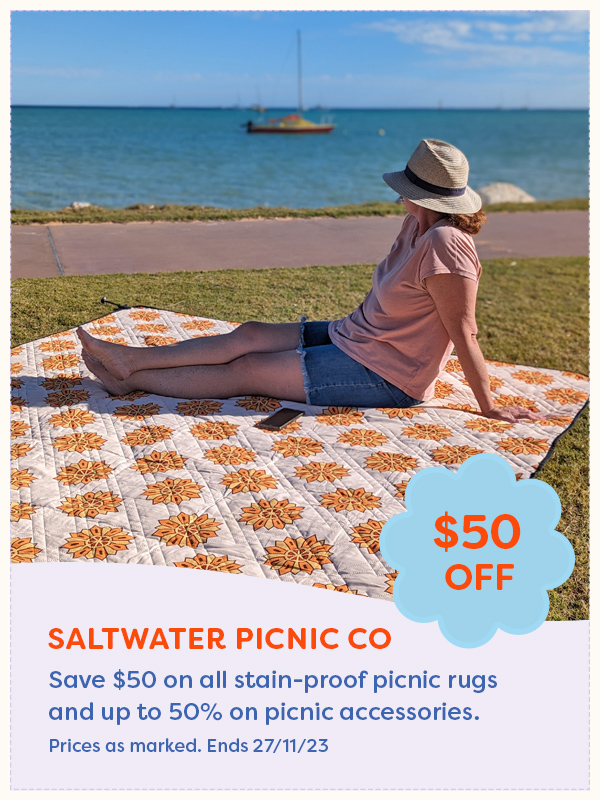 A woman sitting on a Saltwater Picnic picnic rug