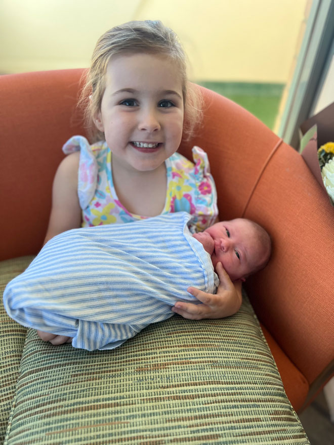 Big sister Zoe holding newborn Imogen 