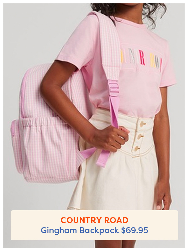Girl holding a pink gingham backpack from country road