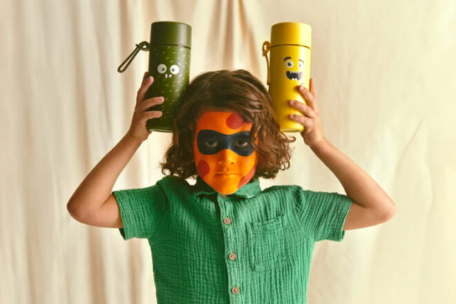 Boy with face paint holding two Frank Green Frankster drink bottles