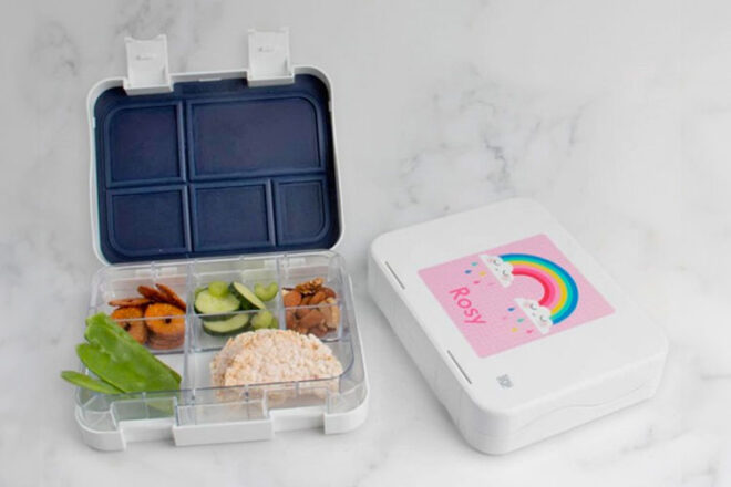 Tinyme Bento Box open and filled with food on a marble background