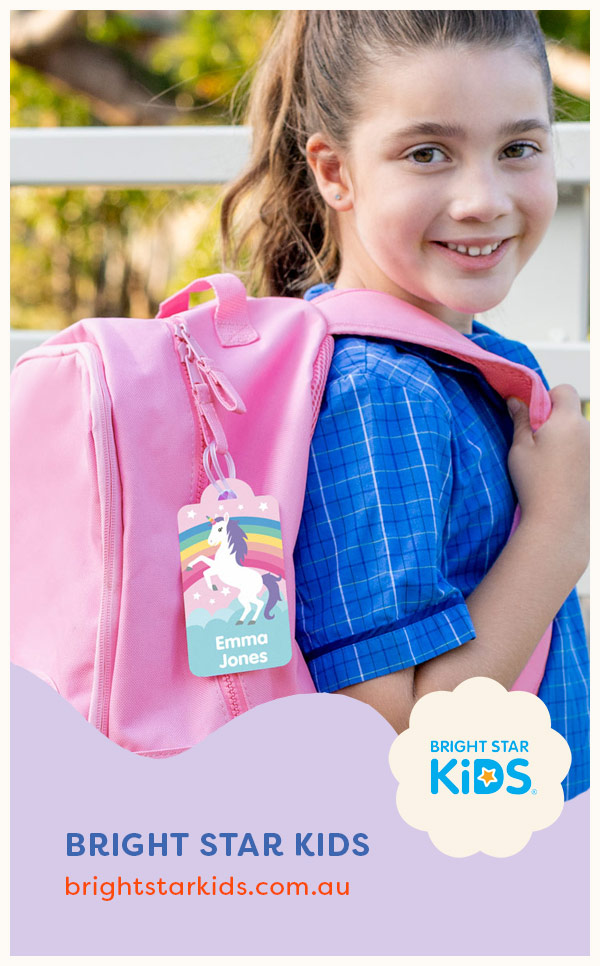Girl holding Bright Start Kids backpack with bag tag