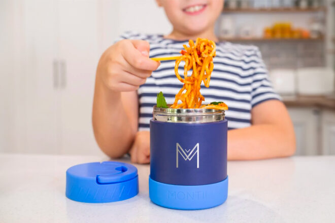 Young boy eating spaghetti from insulated food jar