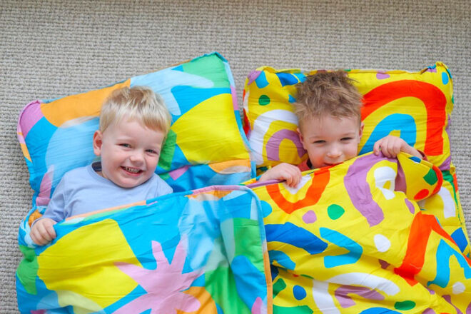 Two children laying in the Morgy + Wills Daycare Nap Mat