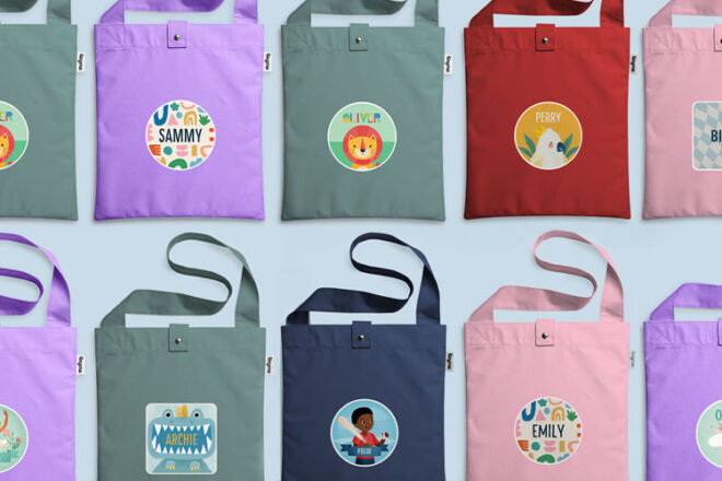 Two rows of Tinyme Library Bags in different colours with a variety of designs on the front of each