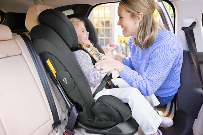 Mouther securing daughter into Joie Centra Car Seat