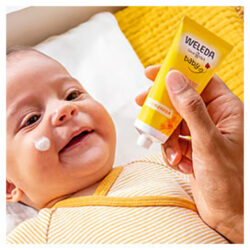 The Weleda Baby Sace Cream being used on a baby's face