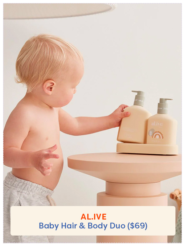 Baby looking at a bottle of Al.ive baby shampoo