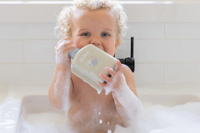 Young child holding Al.ive bubble bath in a bubble bath