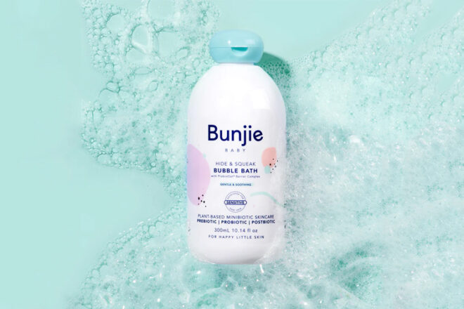 Bottle of Bunjie Bubble Bath lying on blue background with bubbles