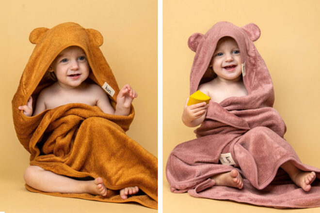 Two babies wearing the Kiin Baby Hooded Bath Towels in Caramel and Heather