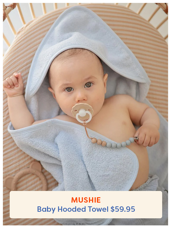 Baby wearing the Mushie Hooded Bath Towel