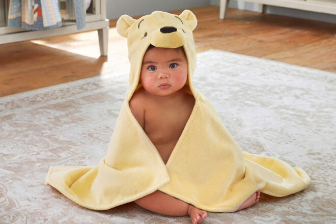 A baby wearing the Winnie the Pooh Pottery Barn Bath Wrap