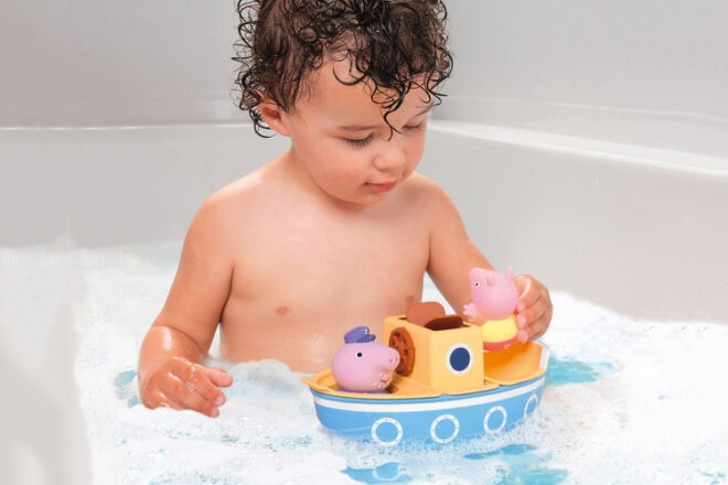 A child playing with the Toomies Grandpa Pig’s Splash & Pour Boat