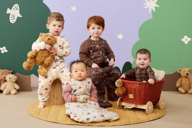 Four children wearing pieces from ergoPouch's Teddy Bear collection