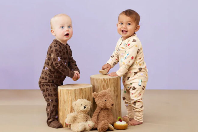 Two babies wearing the ergoPouch long sleeve layer pyjamas 