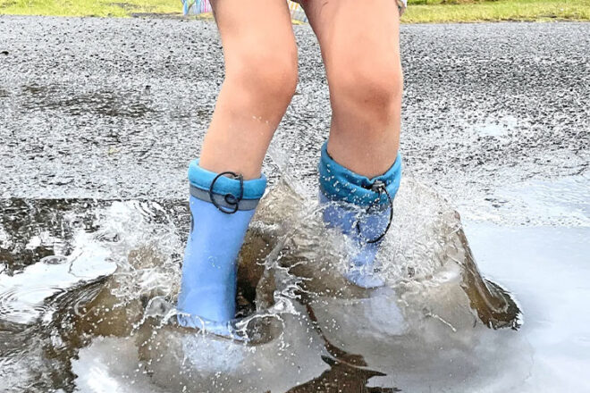 A child playing in a puddle wearing Grubbybub Kids Gumboots 
