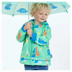 A little boy wearing a Penny Scallan Kids raincoat in the design Dino Rock