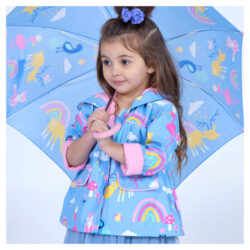 A little girl wearing a Penny Scallan Kids raincoat in the design Rainbow Days