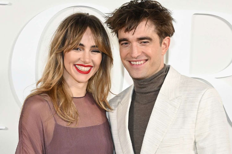 Hollywood couple Robert Pattinson and Suki Waterhouse smiling together on the red carpet