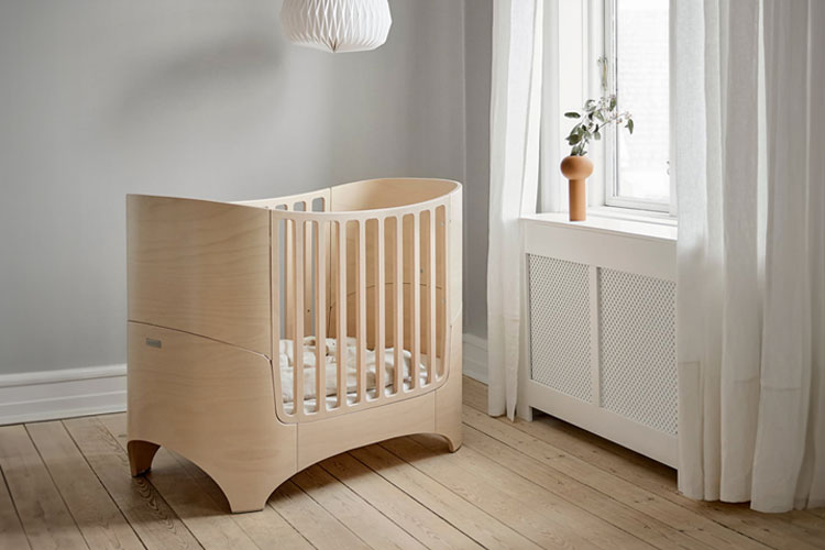 The Leander Classic Baby Cot in Whitewash in the middle of a room