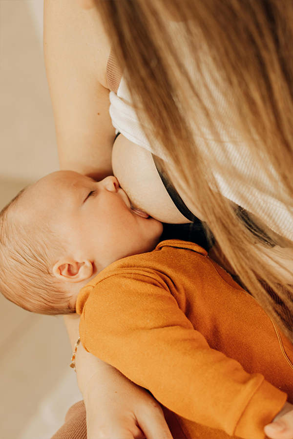 Mother breastfeeding her newborn baby in a nursing chair