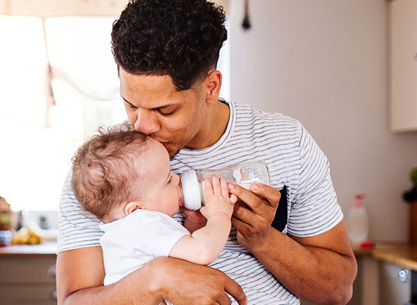 dad feeding baby with a bottle