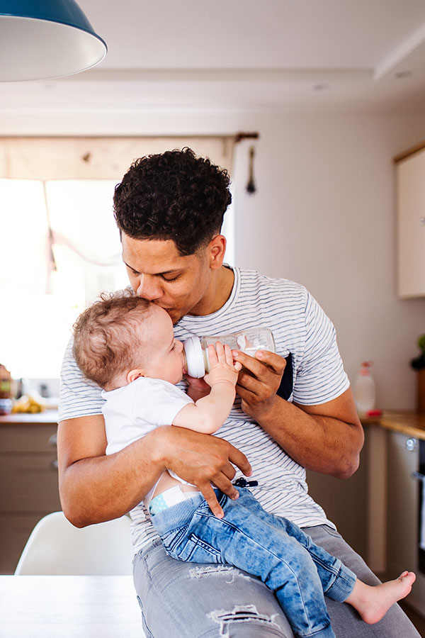 dad feeding baby with a bottle