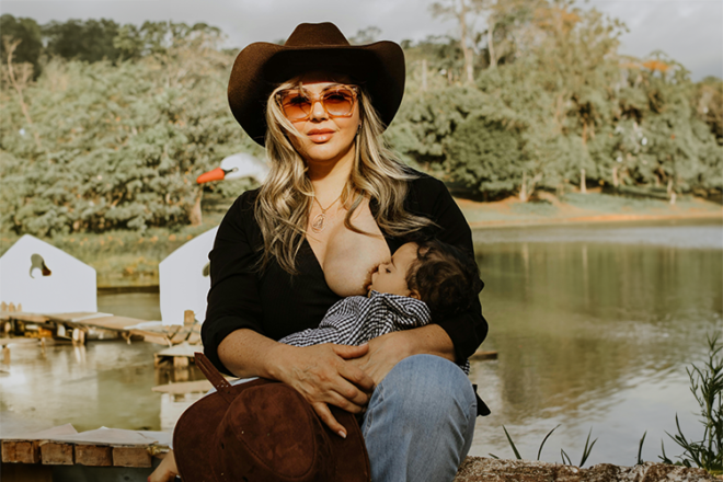 Mother breastfeeding her baby outdoors by a lake in Australia